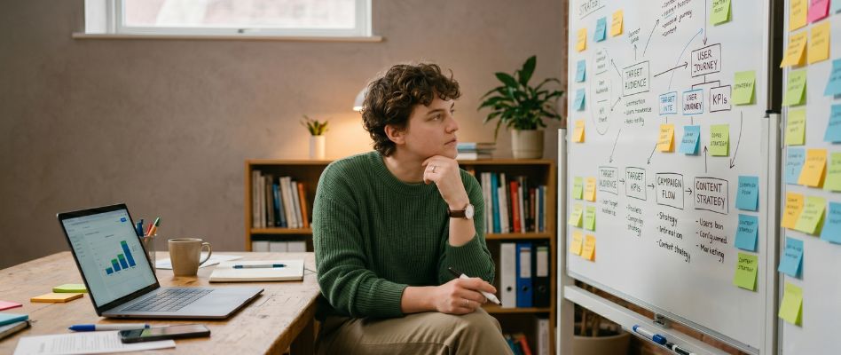 Early-career casino marketer reviewing a strategy framework at a desk with notes and diagrams